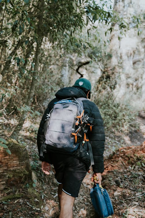 A man walking through the woods with a backpack