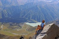 在哈萨克斯坦阿拉木图，一名妇女在山顶欣赏着令人惊叹的景色