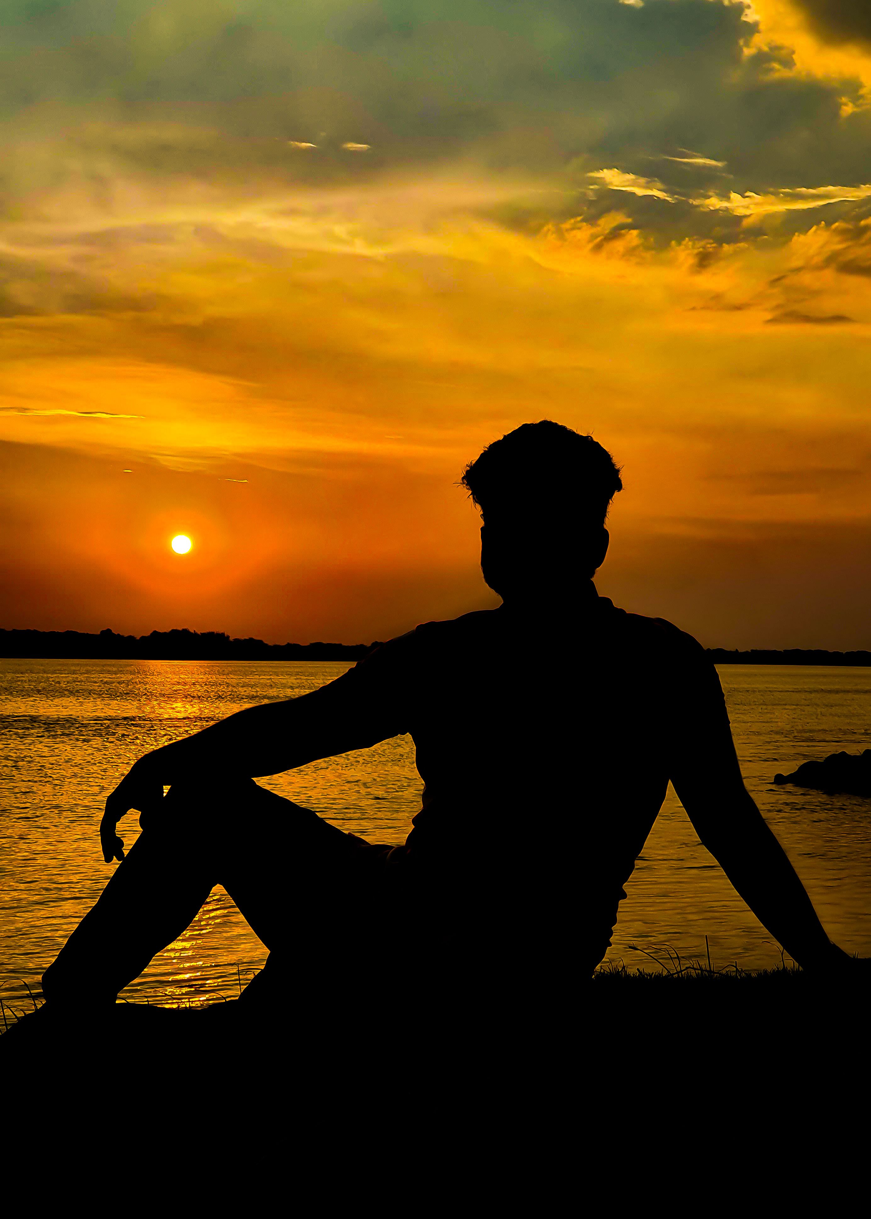 Silhouette of Woman Sitting on Dock during Sunset · Free Stock Photo