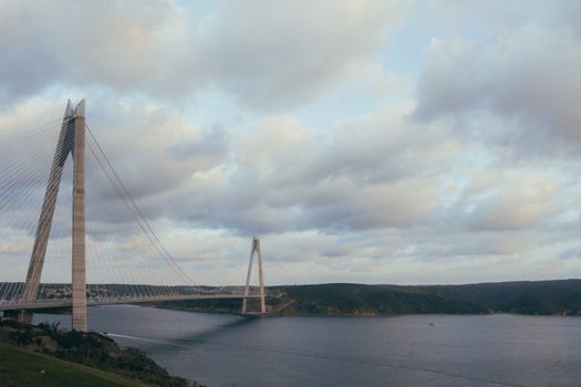 阴沉的天空下，吊桥横跨平静的水面，景色令人惊叹