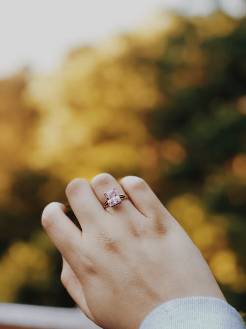 Person Wearing Silver-colored Ring With Pink Stone