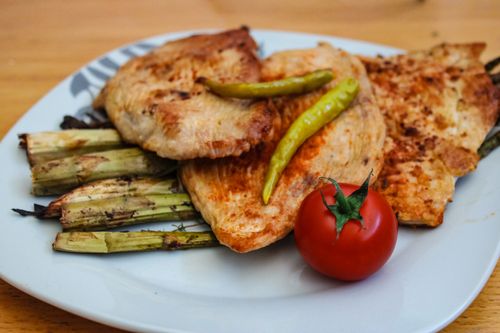 Free A savory plate of grilled chicken with asparagus and a fresh tomato. Stock Photo