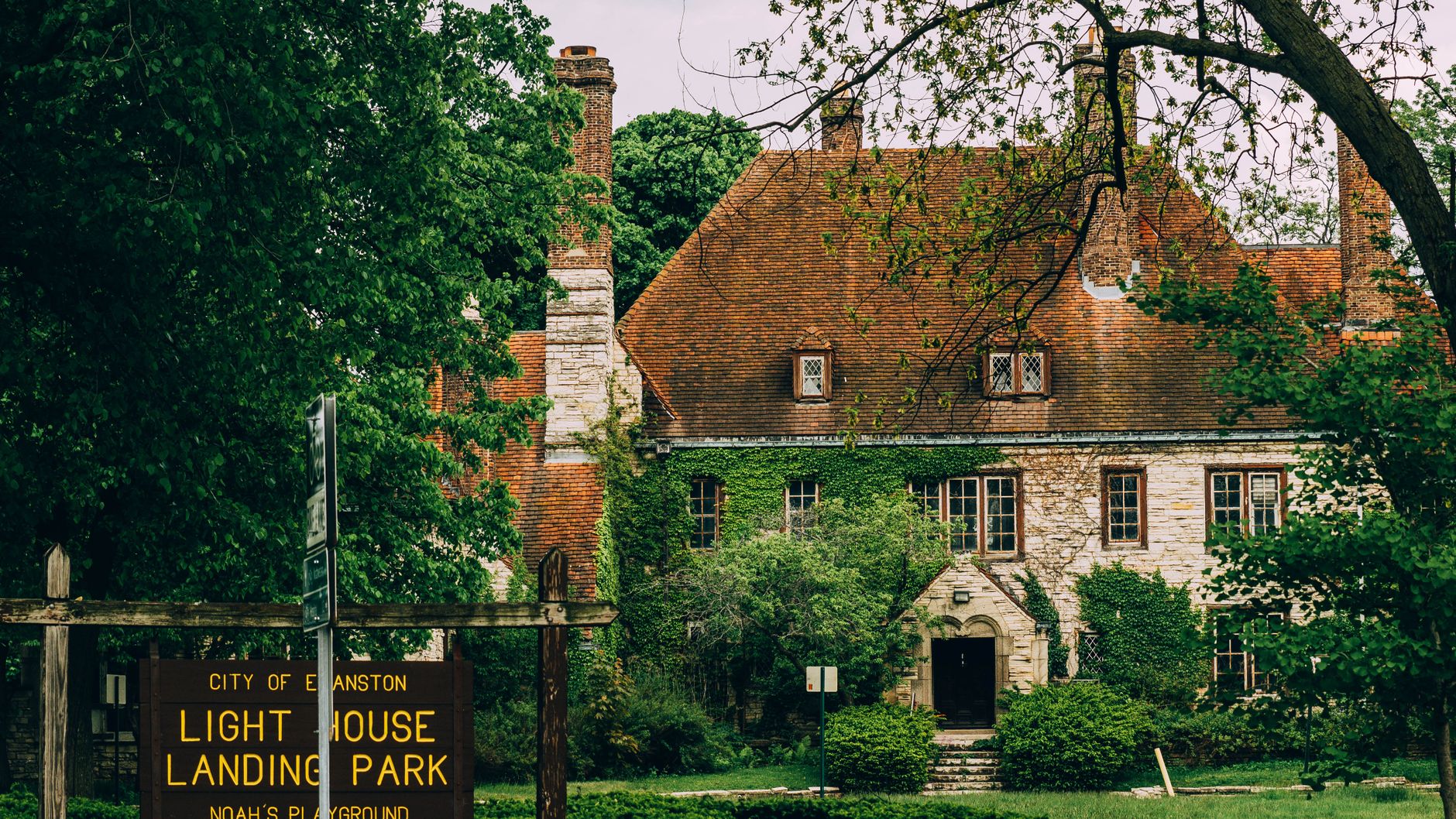 Charming stone house with ivy-covered walls in a lush garden at Lighthouse Landing Park, Evanston.