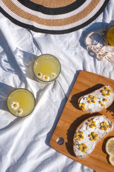 Enjoy a summer picnic with lemon drinks and floral-topped bread on a sunny day.
