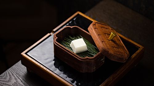 Free An elegant wooden box displayed with a floral arrangement and white cube inside, perfect for artistic home decor. Stock Photo