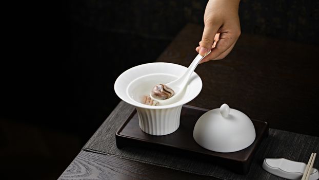 陶瓷锅中正炖煮着色泽红亮的红烧肉，汤汁浓郁。