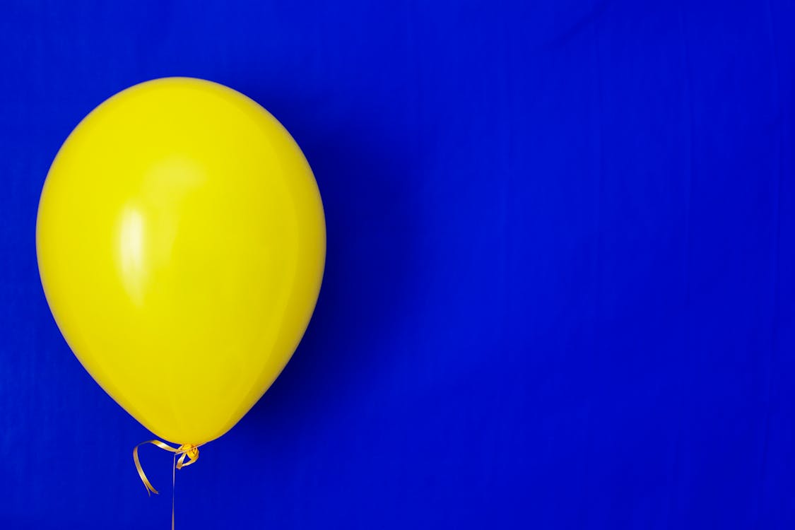 Free Yellow Balloon on Blue Background Stock Photo