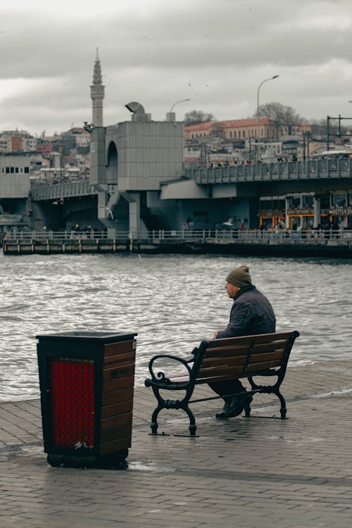 A man sitting on a bench by the water