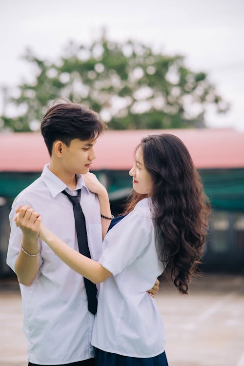 A young couple in school uniforms dancing
