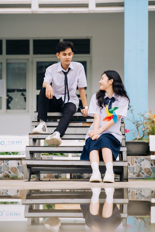 A couple sitting on a bench in front of a building