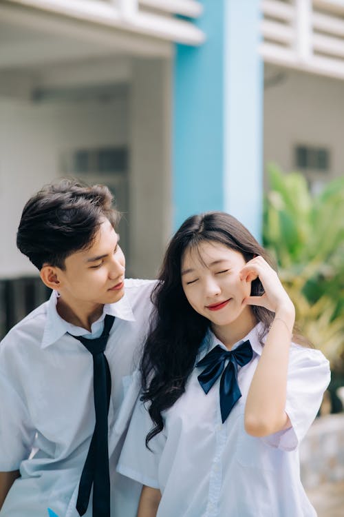 A couple in school uniforms standing next to each other