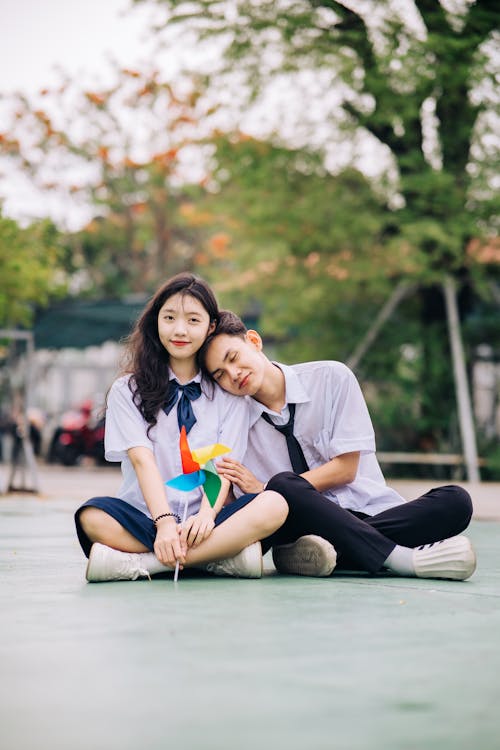 A couple sitting on the ground with a pinwheel