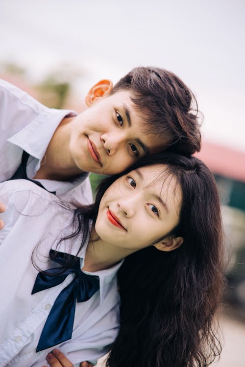 A young couple posing for a photo in school uniforms