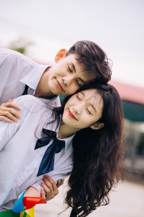 A young couple hugging each other while wearing school uniforms