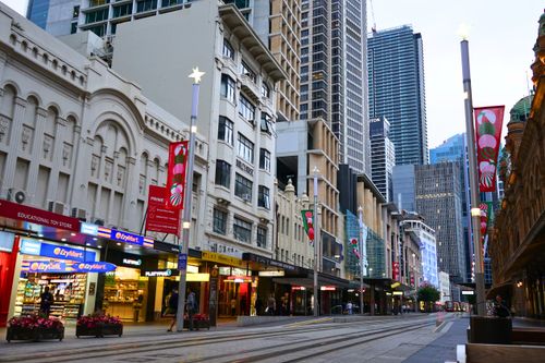 Free A bustling Sydney street scene featuring shops, historic buildings, and skyscrapers under twilight. Stock Photo