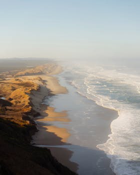 Tranquil aerial view of a seaside landscape showcasing waves and sandy dunes.