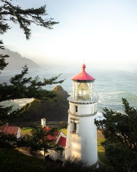 一座美丽的灯塔坐落在岩石海岸上，周围环绕着海景和绿色植物