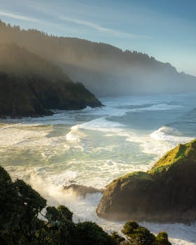 日出时分，薄雾笼罩的悬崖与汹涌的海浪构成了戏剧性的海景