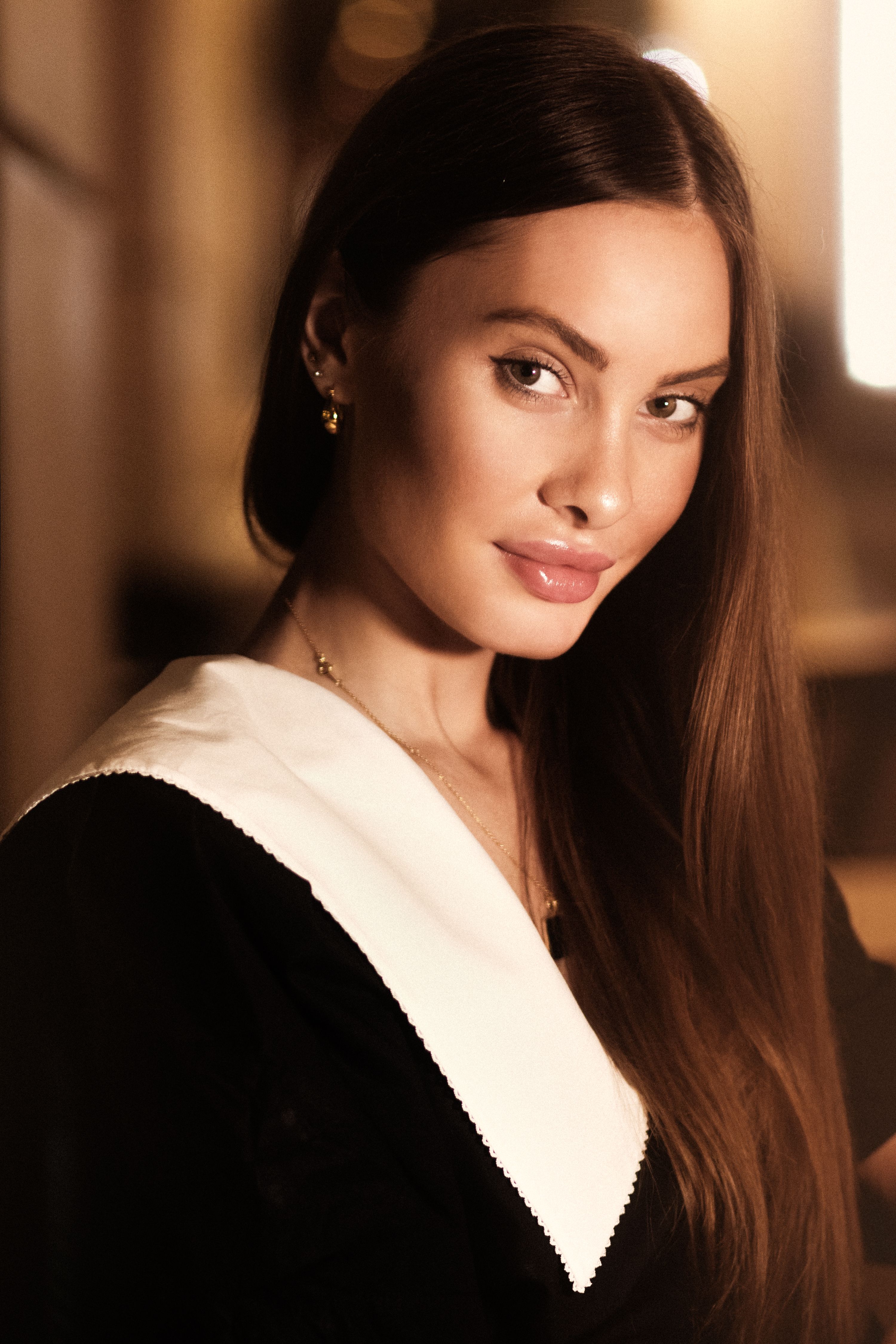 Striking portrait of a woman with long brown hair, creating a sophisticated fashion aesthetic.