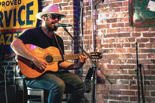 A musician plays acoustic guitar in a Nashville bar setting.