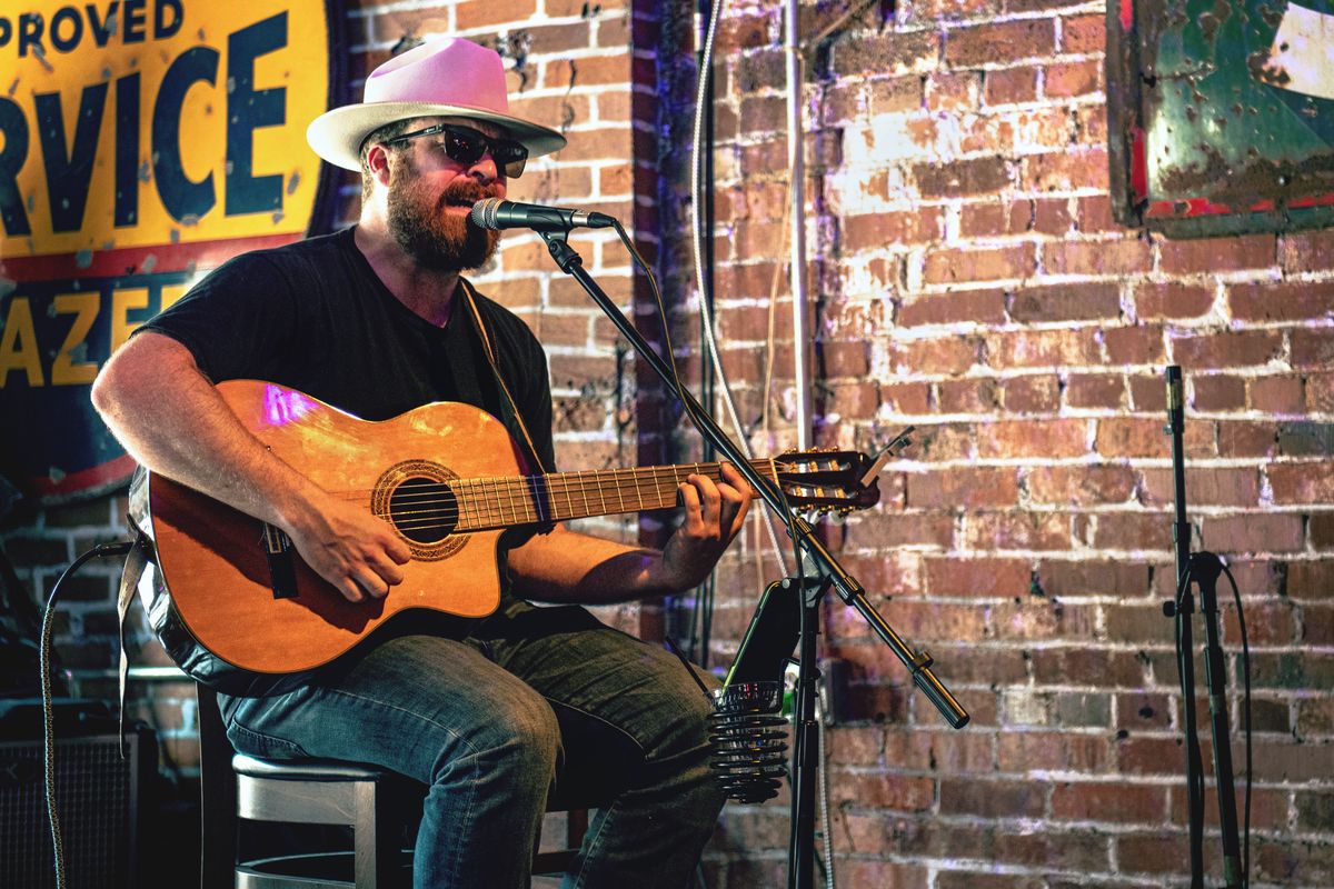 Musicien en chapeau de cowboy jouant de la guitare acoustique dans un bar de Nashville