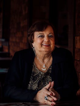 一位资深女性在室内热情微笑，展现优雅