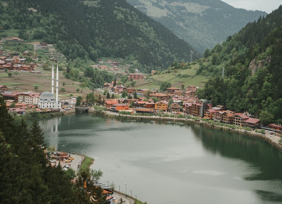 A breathtaking aerial view of Uzungöl Lake surrounded by lush green mountains and traditional architecture in Turkey.