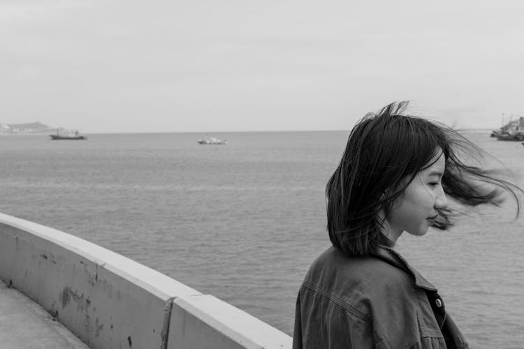 Woman Standing On Sea Shore In Black And White