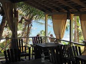 巴巴多斯海边，宁静的露台景观中摆放着木椅和棕榈树