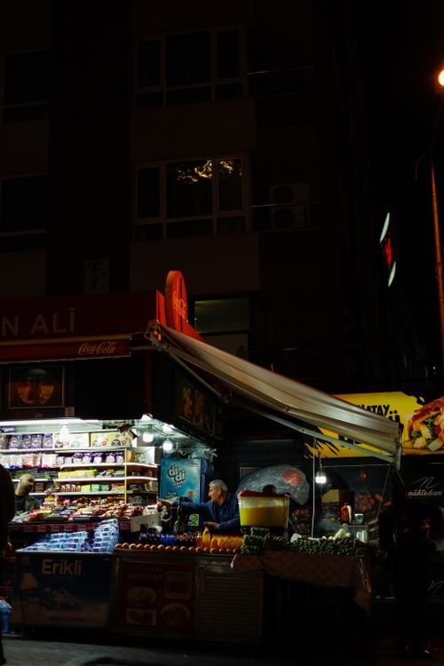 Free A bustling night market stand under streetlights selling various snacks and beverages. Stock Photo