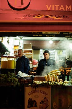 A vibrant night market food stall offering corn and fresh juices, perfect for a taste of local street food.