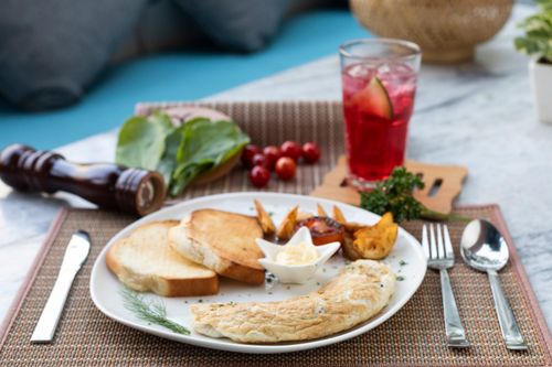 Free Tasty breakfast with omelette and toast on a chic table setting with a refreshing drink. Stock Photo