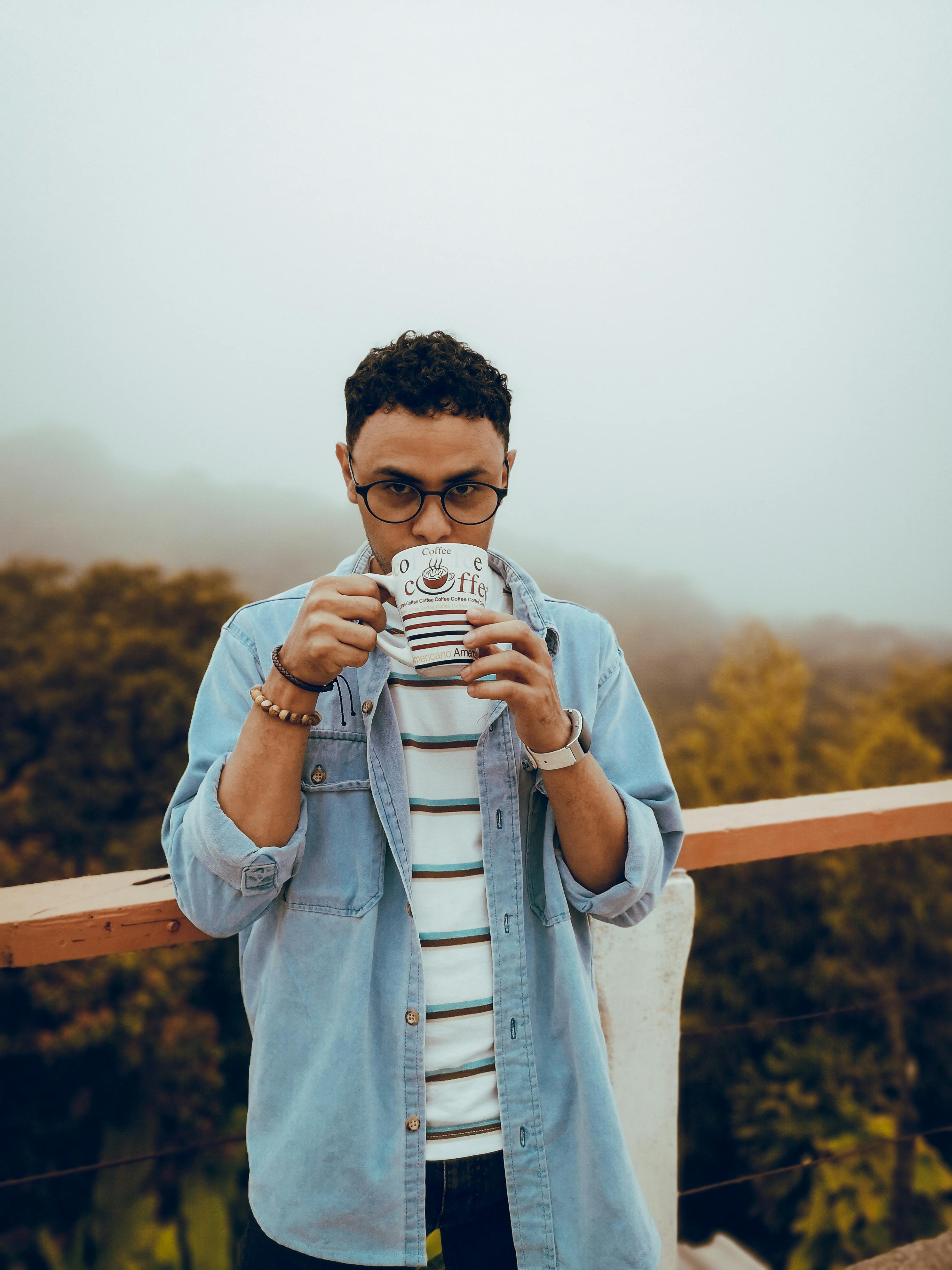 雾蒙蒙的天气里，一位时尚的年轻人在户外喝着咖啡，放松身心