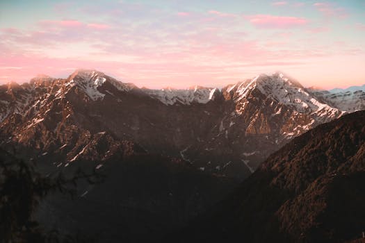 Breathtaking view of snow-covered mountains with a vibrant sunset sky.