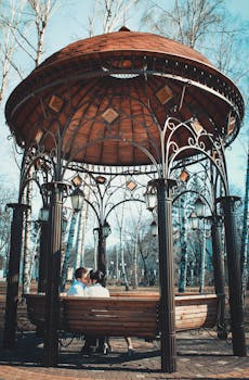 一对夫妇在公园里设计精美的凉亭下共享了浪漫时刻