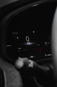 Close-up view of a modern car dashboard showing digital speedometer and controls.