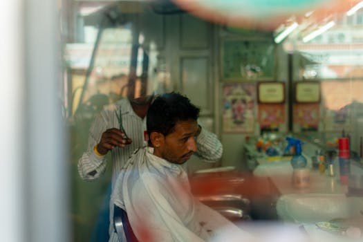 Capture of a barber giving a haircut inside a traditional barbershop in Jaipur, India.