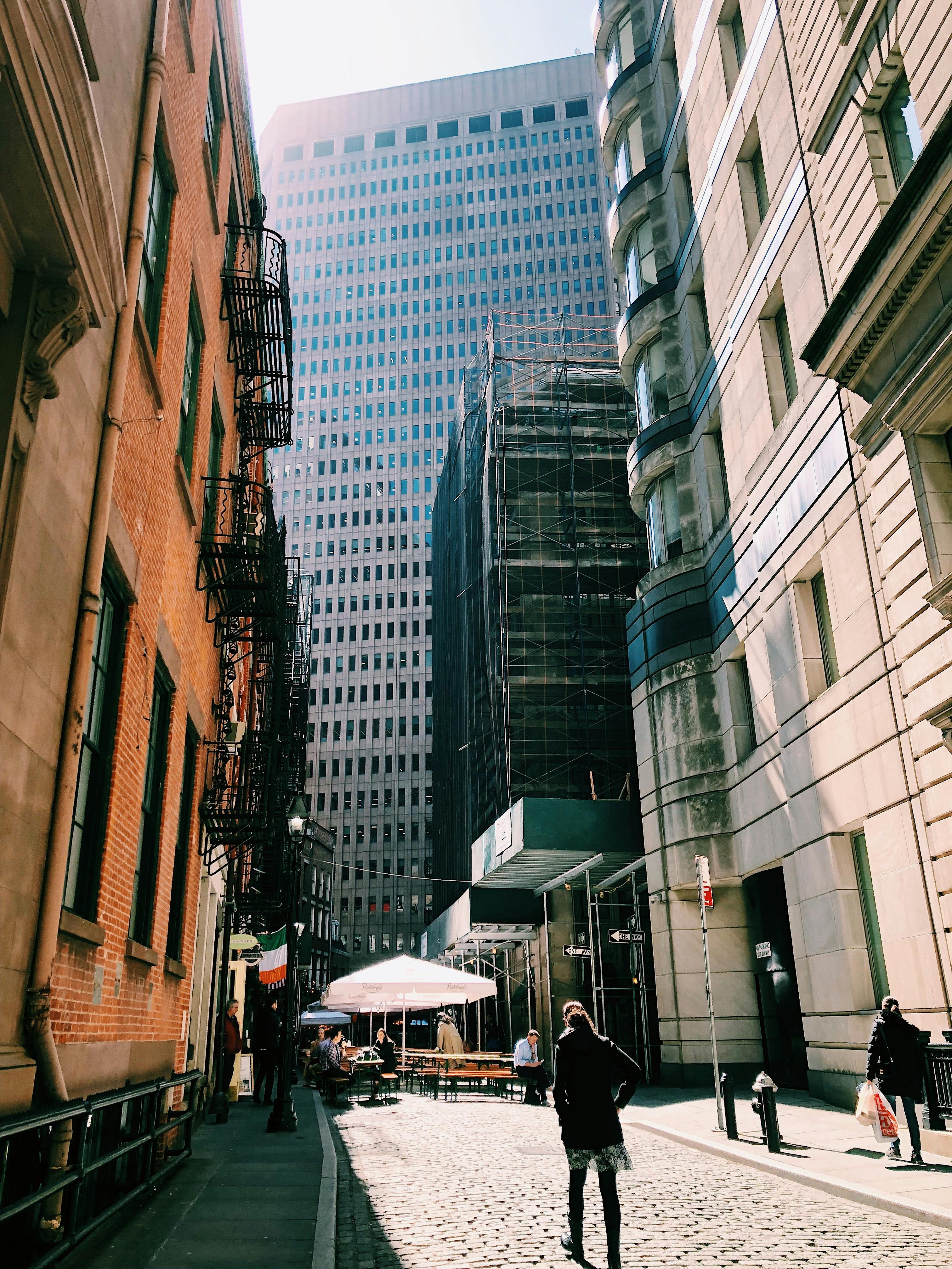 一条繁忙的城市街道，在白天捕捉到了高耸的摩天大楼和城市生活的景象