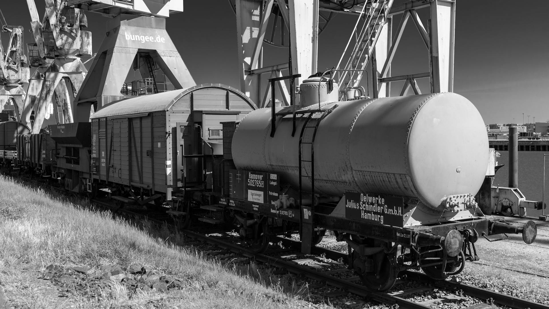 Black and white image of an old train at Hamburg port highlights industrial history.