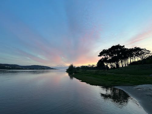Sunset sky over the river Minho and the pine trees on its shores, Eiras, O Rosal, Galicia, Spain, April 2023
