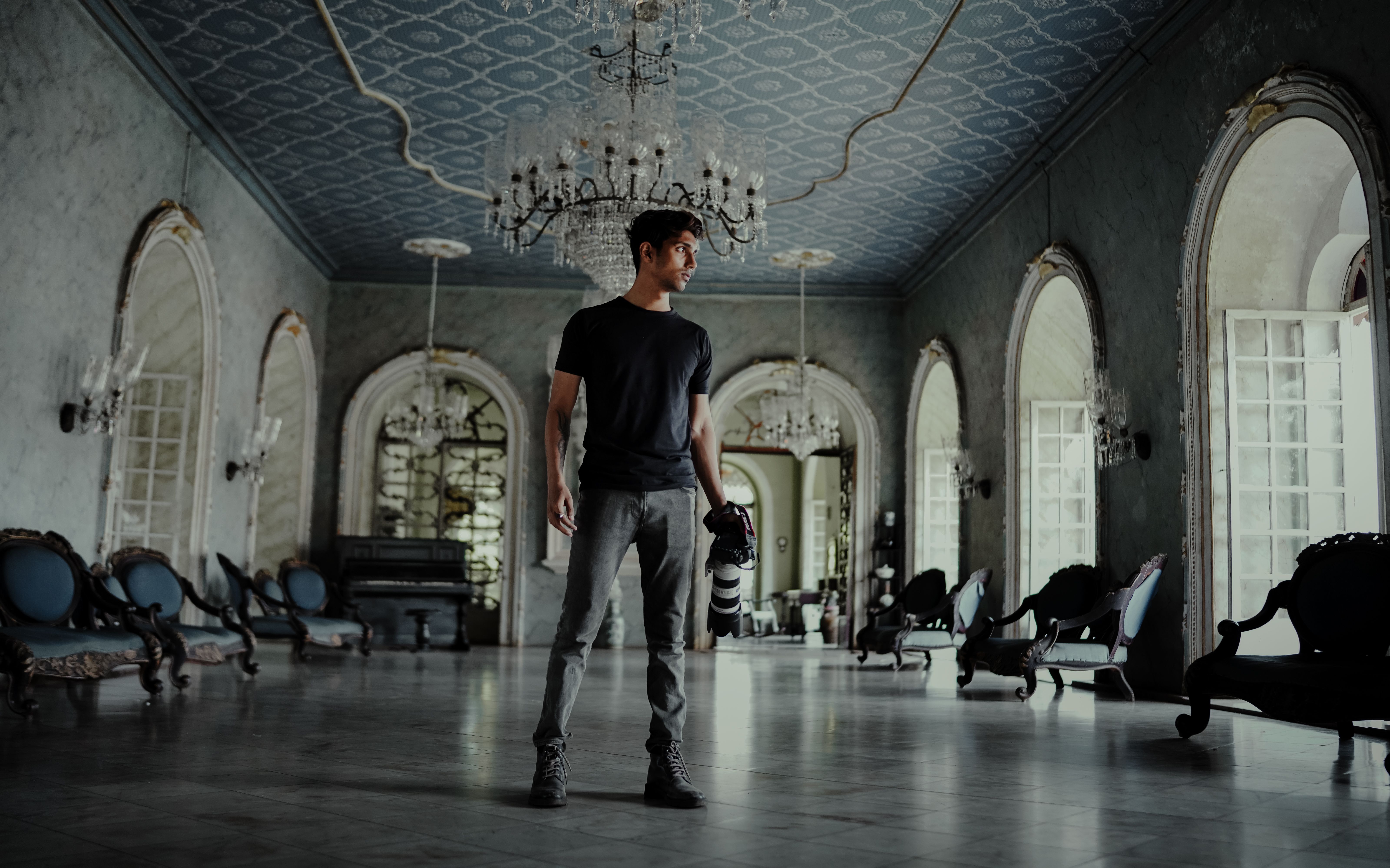Young photographer inside a historical Portuguese-style mansion in India, standing with camera in hand.