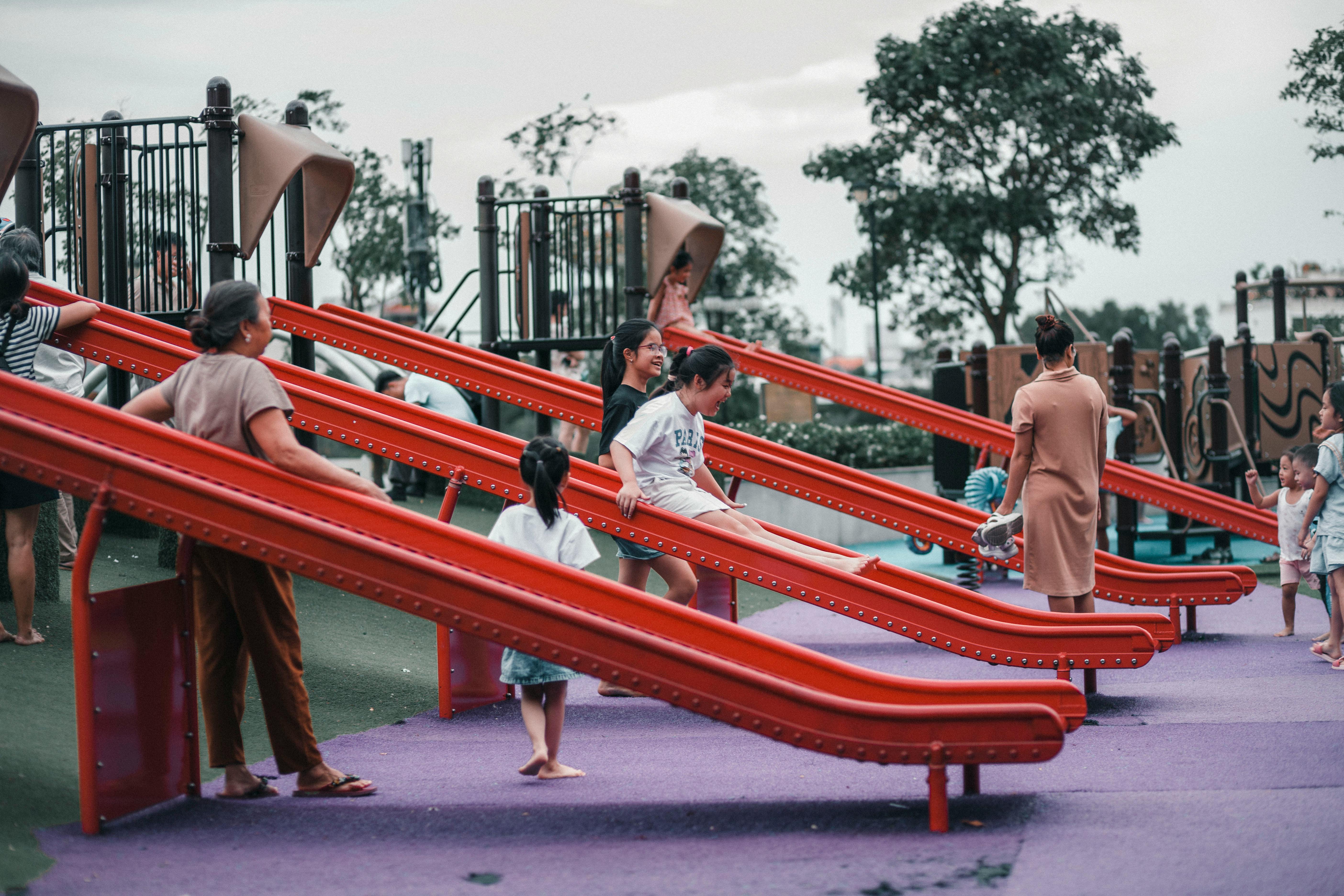 Children playing safely on a colorful rubber bark playground in a community park - rubber bark play area Charlotte NC
