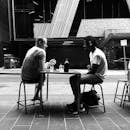 Photo of Two Men Talking While Sitting on Chair