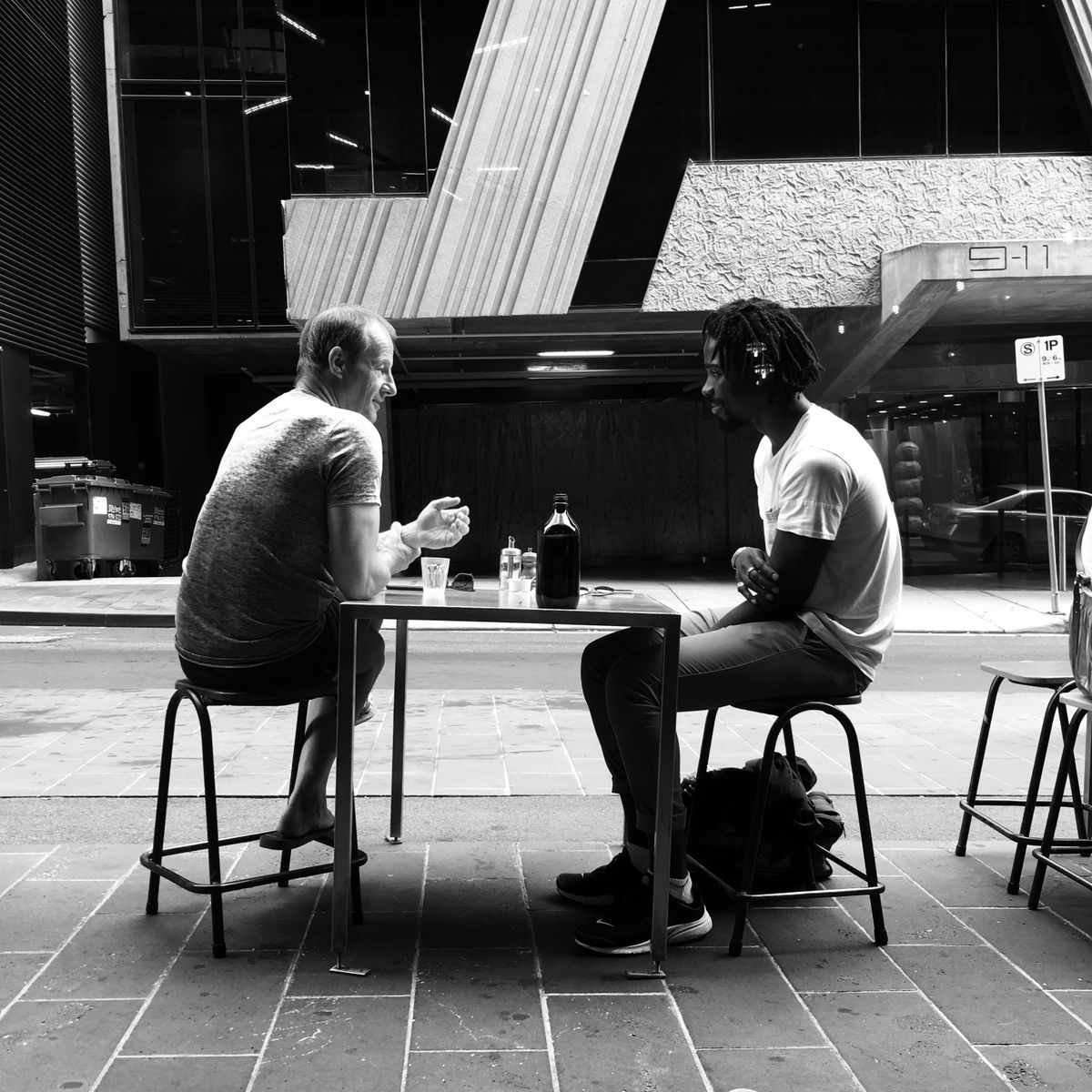 Two men sitting together in honest conversation — peer support and friendship