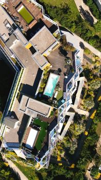 Top view of a modern luxury residential rooftop with terraces and a swimming pool.