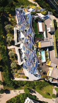 Aerial view of a modern residential building with unique architecture and rooftop pool.