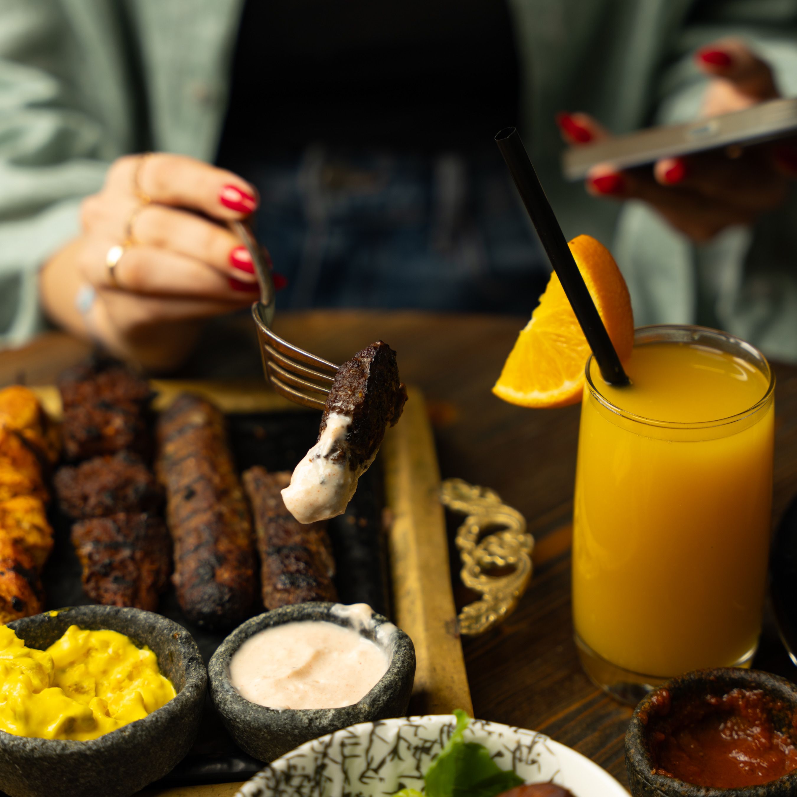 Grilled meats with sauces and fresh juice, creating a perfect meal ambiance.
