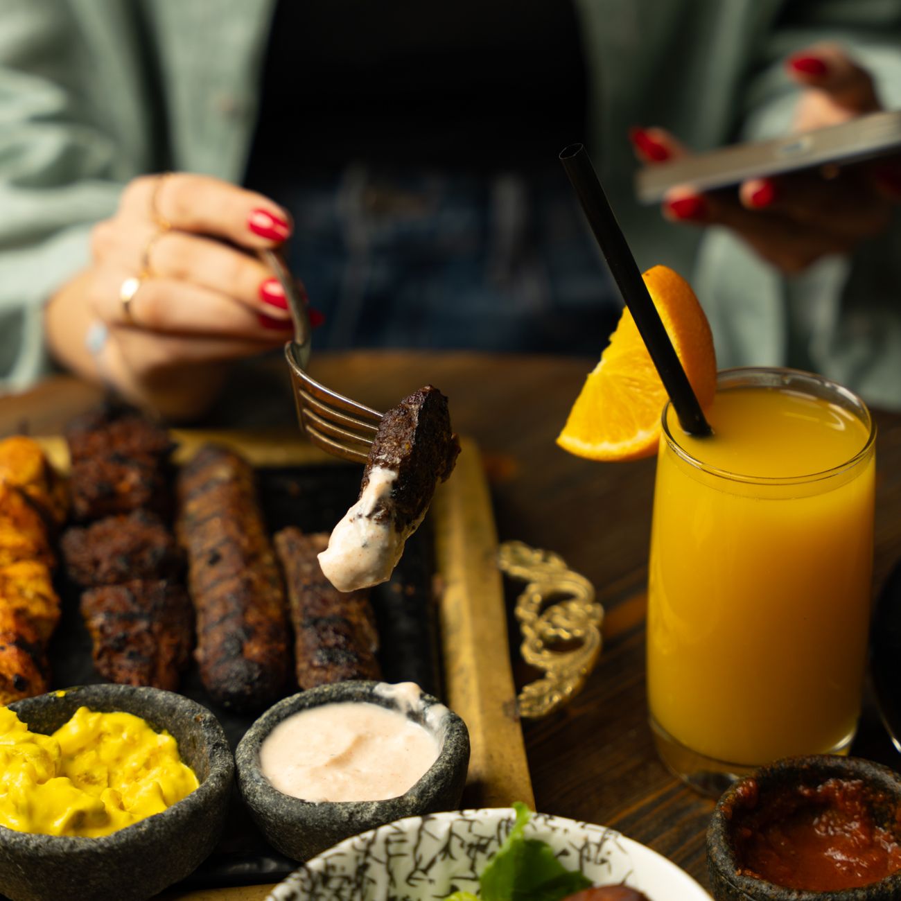 Grilled meats with sauces and fresh juice, creating a perfect meal ambiance.