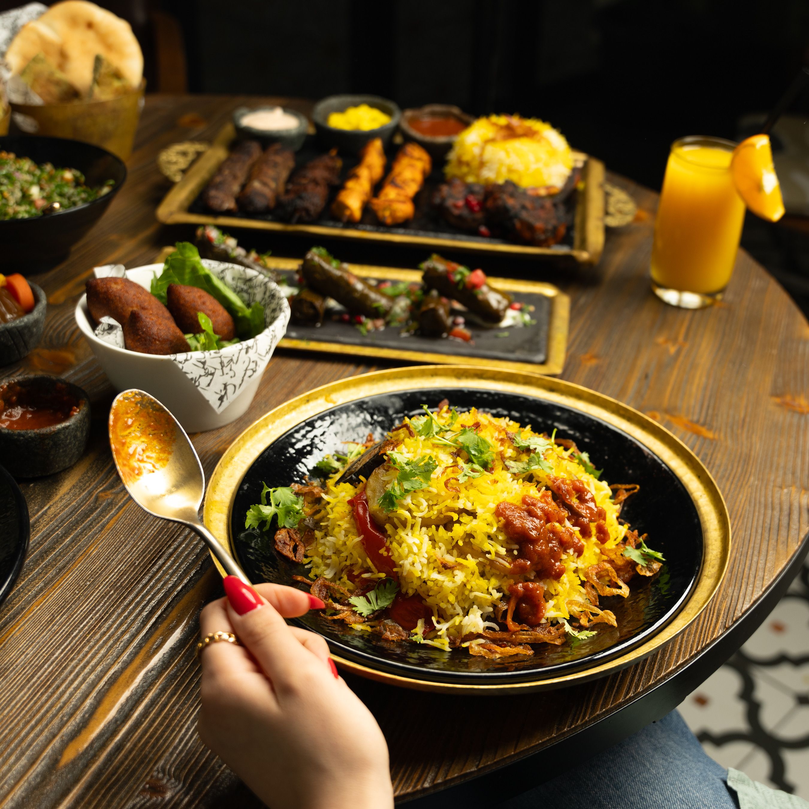 A vibrant and diverse Middle Eastern meal featuring biryani, kebabs, and starters. Perfect for food enthusiasts.