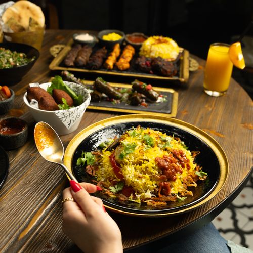 Free A vibrant and diverse Middle Eastern meal featuring biryani, kebabs, and starters. Perfect for food enthusiasts. Stock Photo
